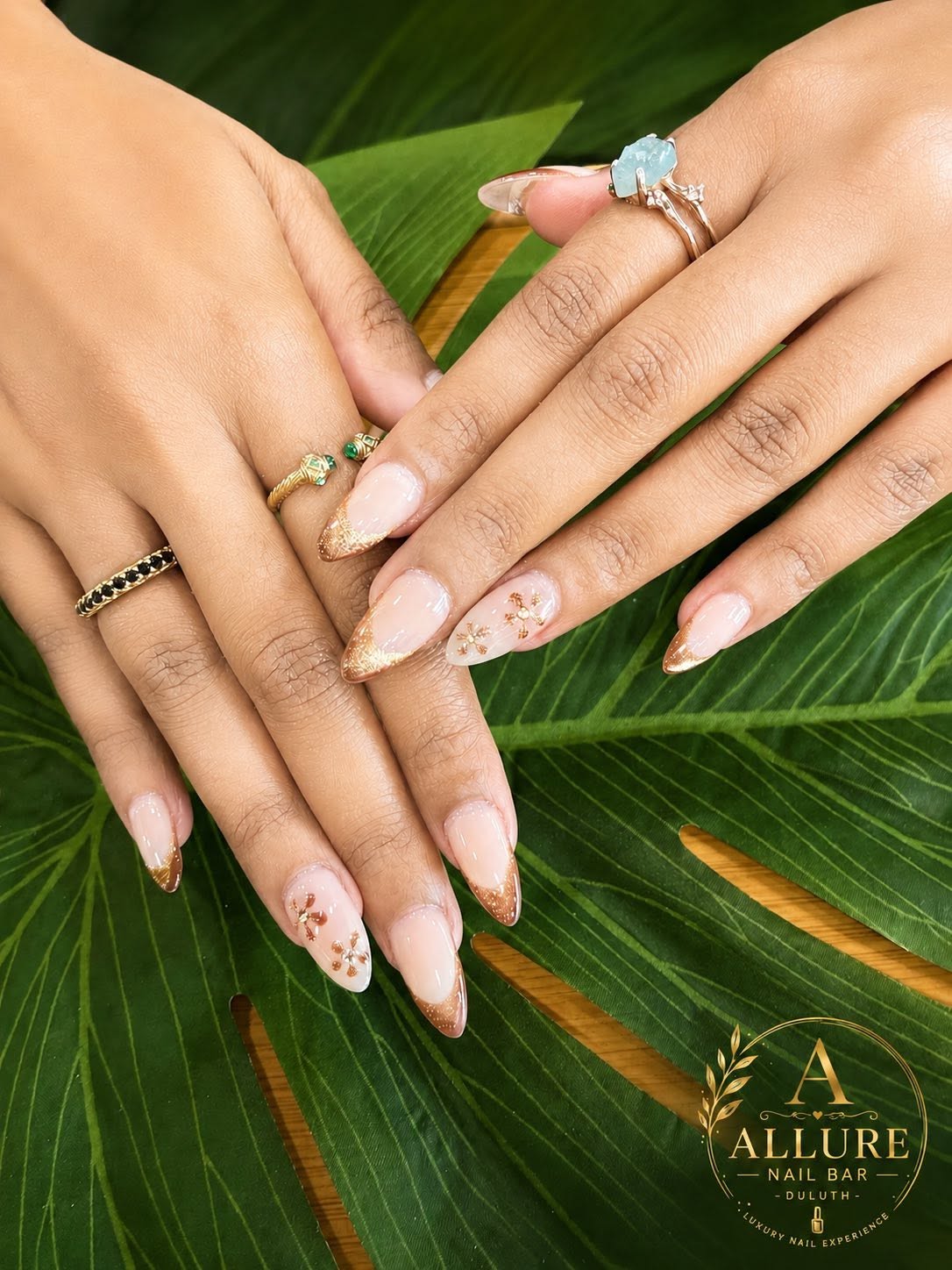 Gold glitter French tip with snowflake charm accent at Allure Nail Bar Duluth